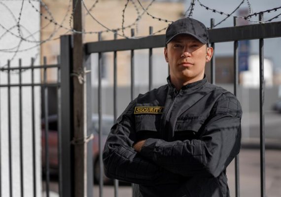 portrait-male-security-guard-with-barbed-wire-fence_23-2150368756