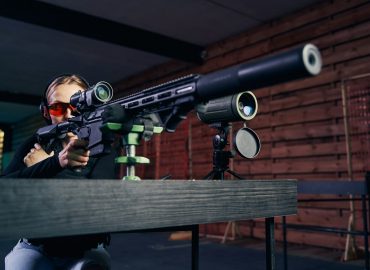 Sniper shooting a firearm with a riflescope